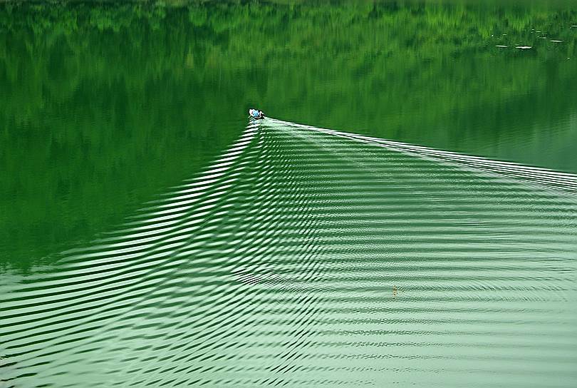 Шиянь, Китай. Мужчина рыбачит на озере
