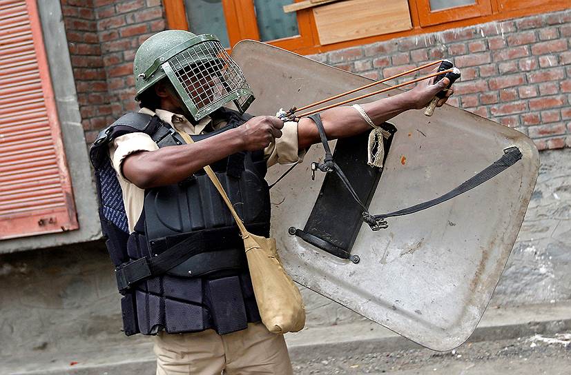 Срингар, Индия. Полицейский стреляет из рогатки во время акции протеста против недавних убийств в Кашмире