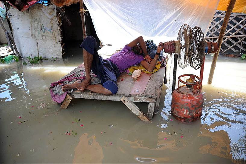 Аллахабад, Индия. Мужчина отдыхает в своем доме, затопленном вышедшей из берегов рекой Ганг