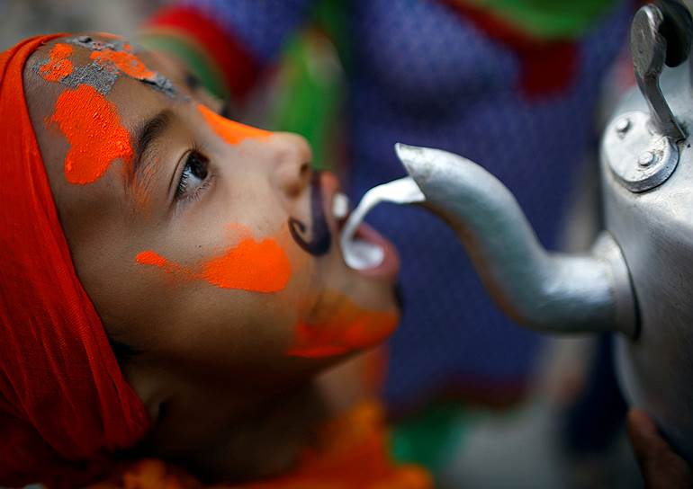 Катманду, Непал. Мальчик пьет молоко во время Гайатри фестиваля или фестиваля коров