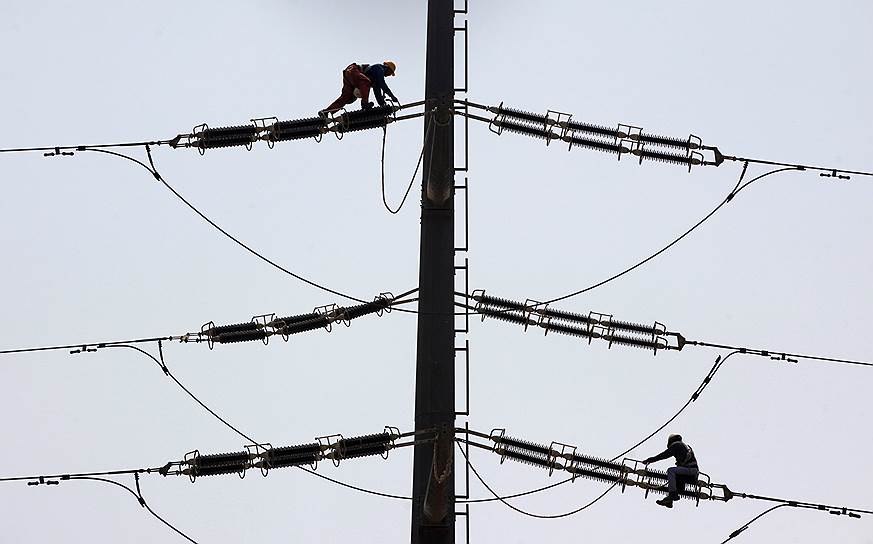 Карачи, Пакистан. Рабочие чинят линию электропередачи  