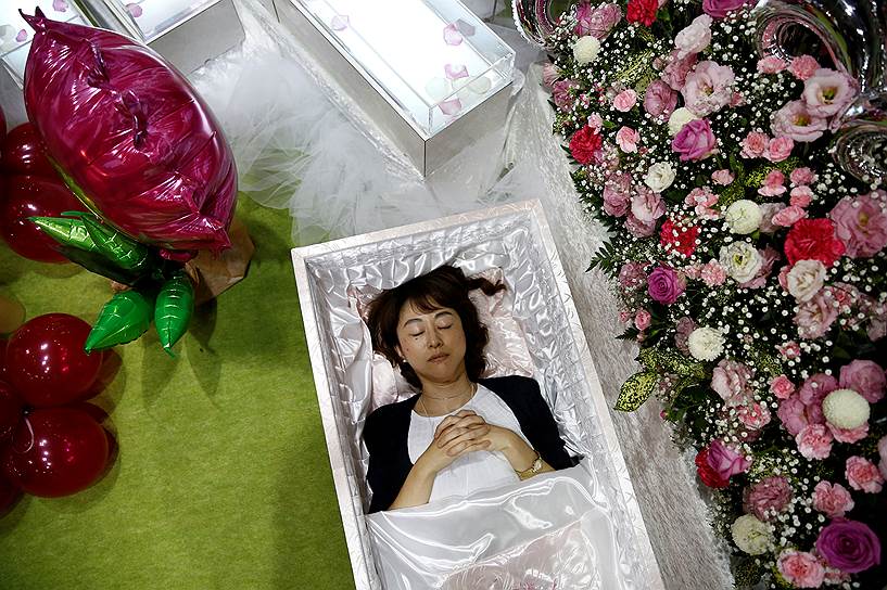 Токио, Япония. Работница лежит в гробу в ходе демонстрации сервиса похоронных услуг на выставке
