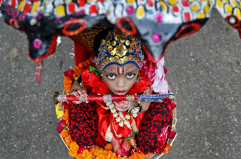Дакка, Бангладеш. Ребенок одетый в костюм бога Кришны на фестивале Кришна-джанмаштами
