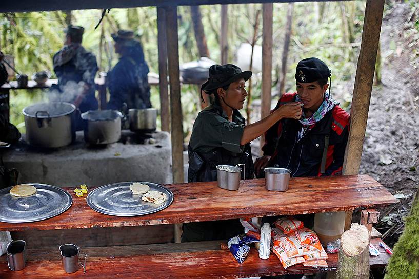 Служащие FARC Юли и Эдвар обедают в лагере