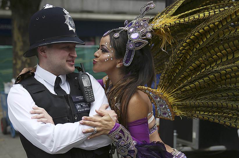 Лондон, Великобритания. Танцовщица и полицейский во время Ноттинг-Хиллского карнавала