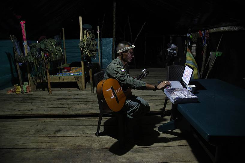 Член FARC учится играть на гитаре по видеороликам в интернете
