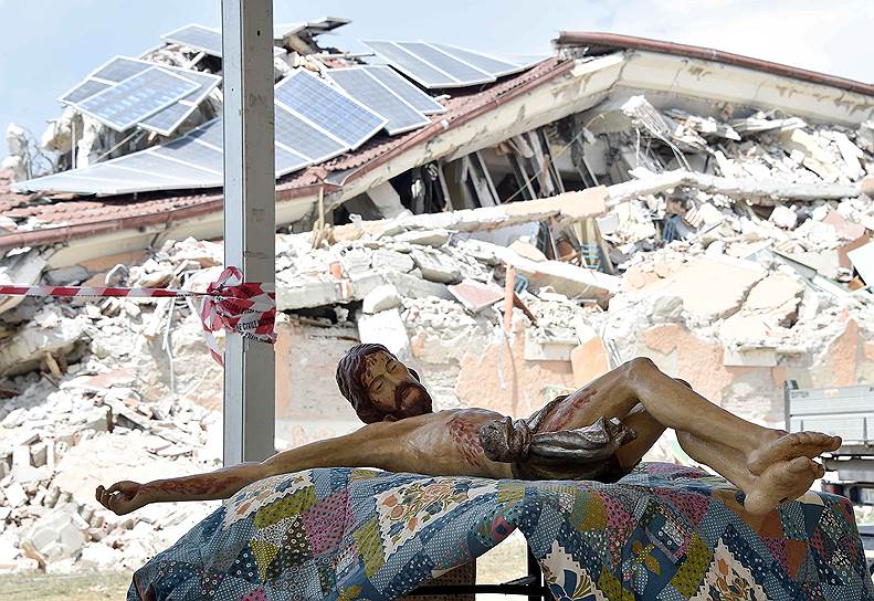 Аматриче, Италия. Статуя Иисуса Христа, лежащая на столе перед началом церемонии похорон жертв землетрясения