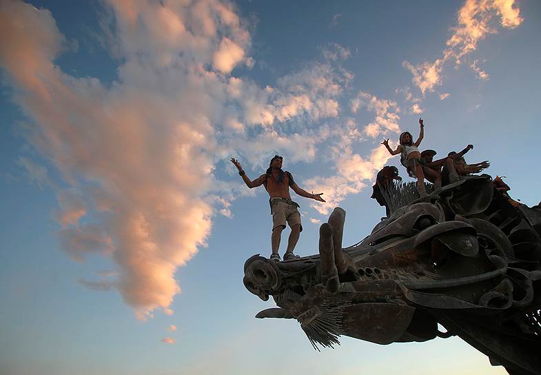 Пустыня Блек-Рок, США. Участники ежегодного фестиваля Burning Man танцуют на статуе дракона