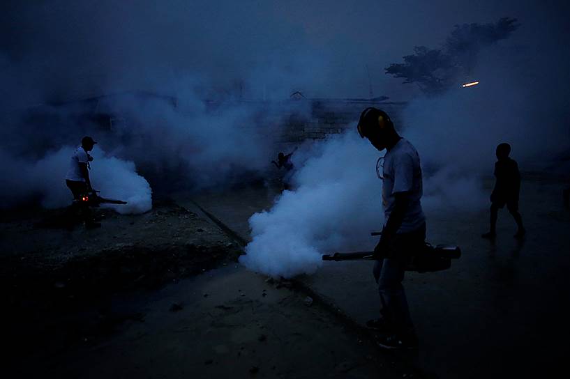 Порт-о-Пренс, Гаити. Сотрудники Министерства здравоохранения окуривают землю, чтобы предотвратить размножение комаров переносящих малярию и вирус Зика 
