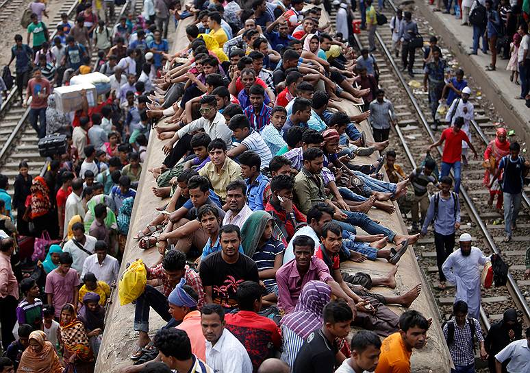 Дакка, Бангладеш. Местные жители сидят на вагоне пассажирского поезда во время отправления