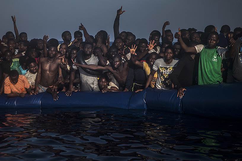 Средиземное море, 13 миль к северу от Сабраты (Ливия). Африканские беженцы и мигранты на борту тонущей резиновой лодки в ожидании спасателей