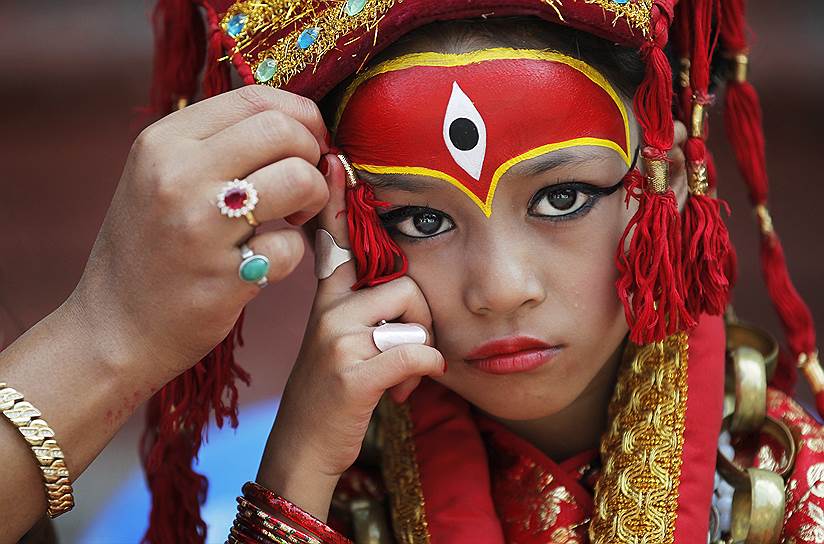 Катманду, Непал. Девочка, одетая в костюм богини Кумари, перед традиционным праздником в честь божества