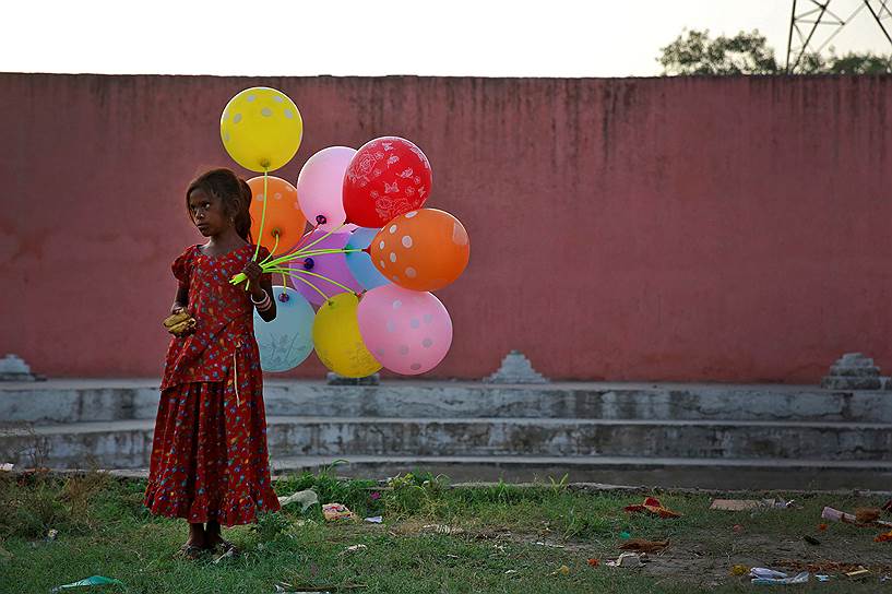 Дели, Индия. Девочка продает шары во время праздника Ганеша-чатуртхи