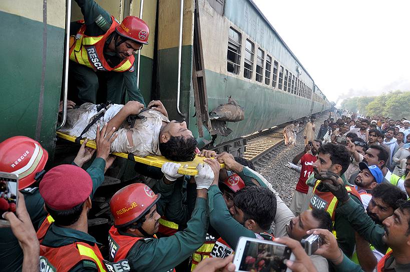 Мултан, Пакистан. Спасатели эвакуируют раненного в результате столкновения двух поездов пассажира