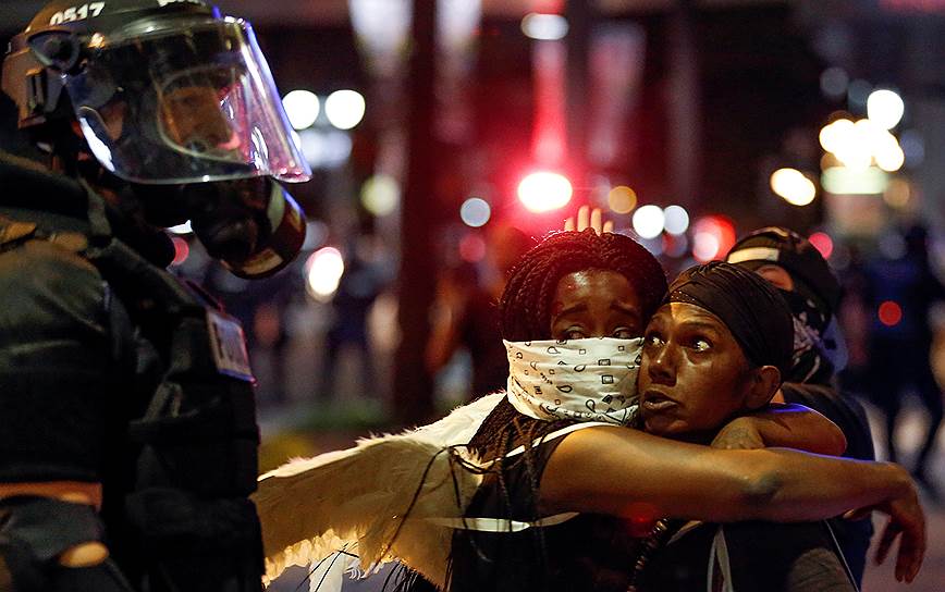 Шарлотт, США. Женщины и полицейский во время протестов. Волнения в городе продолжаются уже несколько дней после того, как полицейский застрелил безоружного афроамериканца