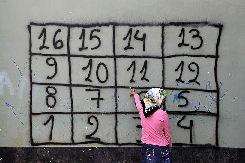 Афины, Греция. Афганская девочка во время занятий математикой, организованных НКО в лагере для мигрантов
