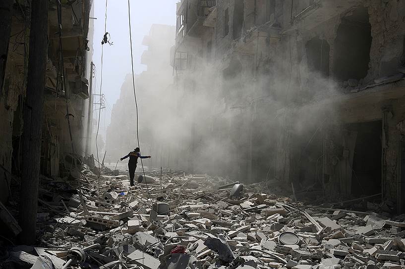 Аль-Катарджи, Сирия. Мужчина идет по обломкам зданий, разрушенных в результате авиаудара