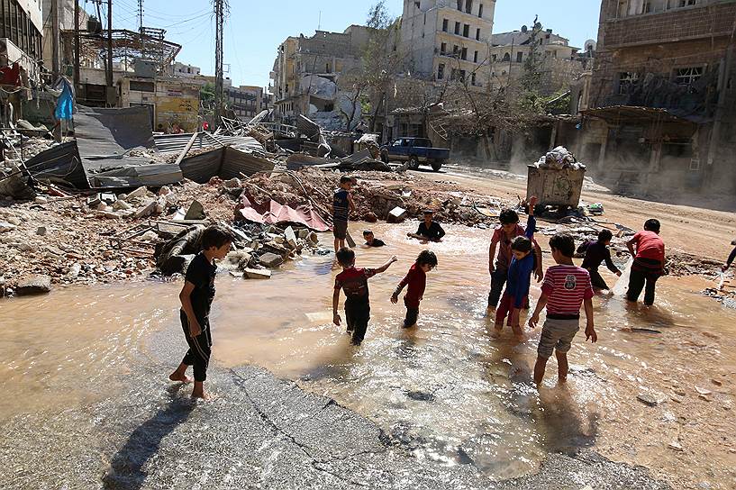 Алеппо, Сирия. Дети играют в лужах, после того как в результате авиаудара был уничтожен водопровод в подконтрольном повстанцам районе города
