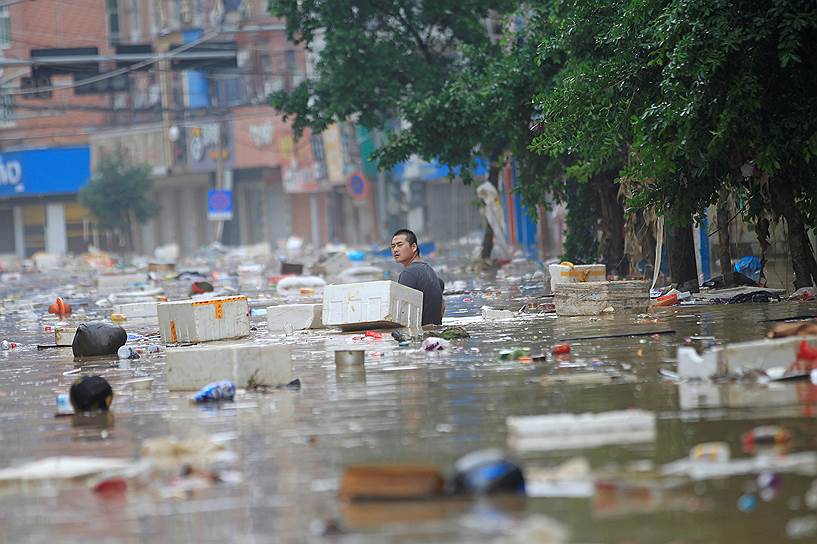Вэньчжоу, Китай. Мужчина переходит затопленную в результате наводнения улицу  