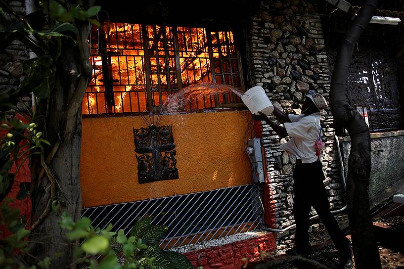 Порт-о-Пенс, Гаити. Мужчина помогает тушить пожар в ресторане 