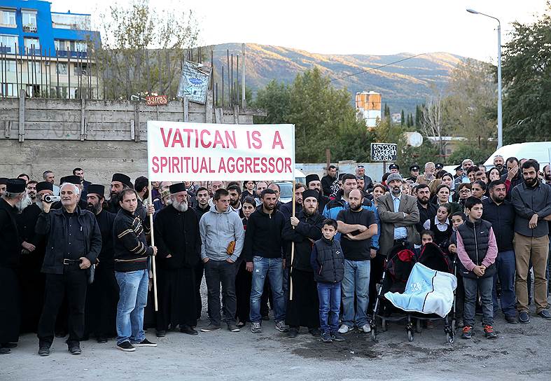 Протестующие держат плакат «Ватикан — духовный агрессор»
