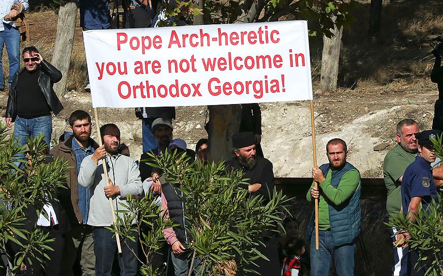 Протестующие против визита главы Римско-католической церкви держат плакаты «Папа Франциск — еретик, и его не приветствуют в Грузии!»