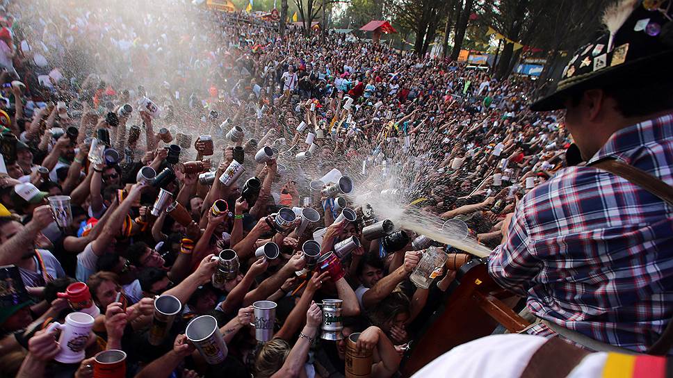 Вилья Хенераль Бельграно, Аргентина. Посетители пивного фестиваля подставляют кружки под разливающийся на них напиток