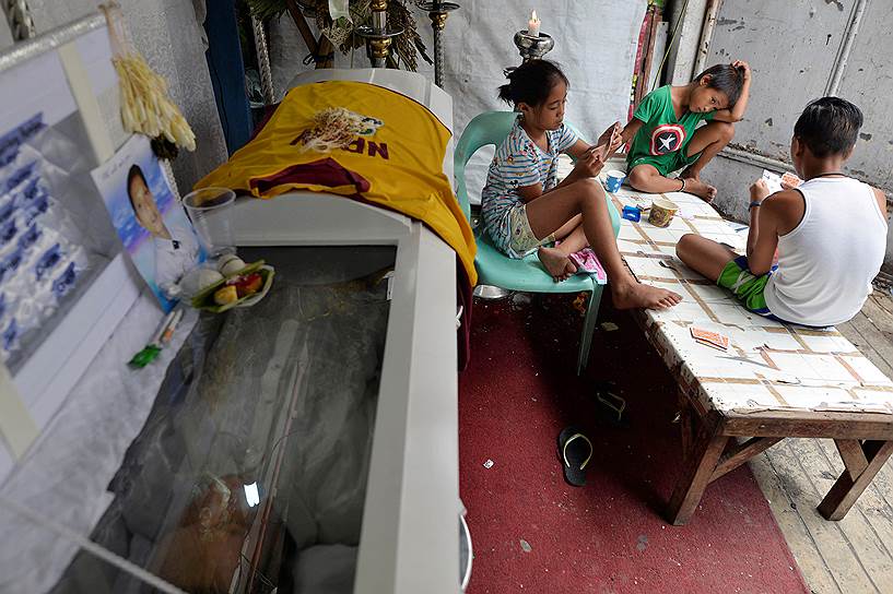 Манила, Филиппины. Дети играют в карты во время похорон убитого наркоторговцами мужчины
