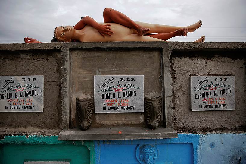 Манила, Филиппины. Ребенок с манекеном на гробницах жертв нарковойны
