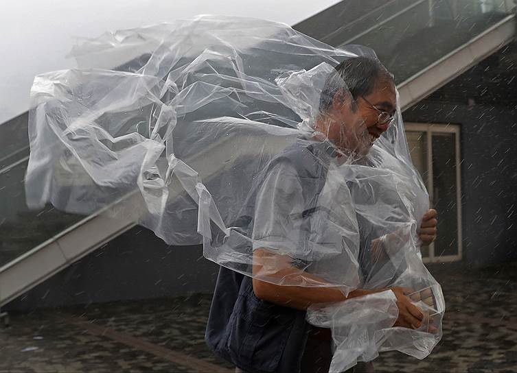 Гонконг. Мужчина идет против ветра. В пятницу по городу ударил мощный тайфун Хайма  