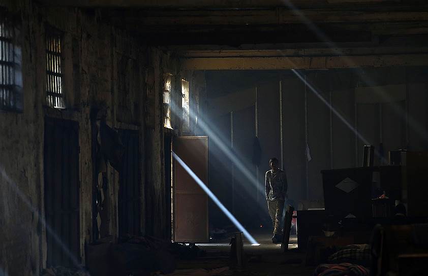 Белград, Сербия. Мигрант на заброшенном складе, который беженцы используют в качестве временного приюта