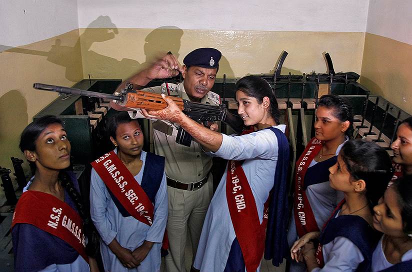 Чандигарх, Индия. Полицейский объясняет школьницам, как работает огнестрельное оружие, во время празднования 50-летия местной полиции
