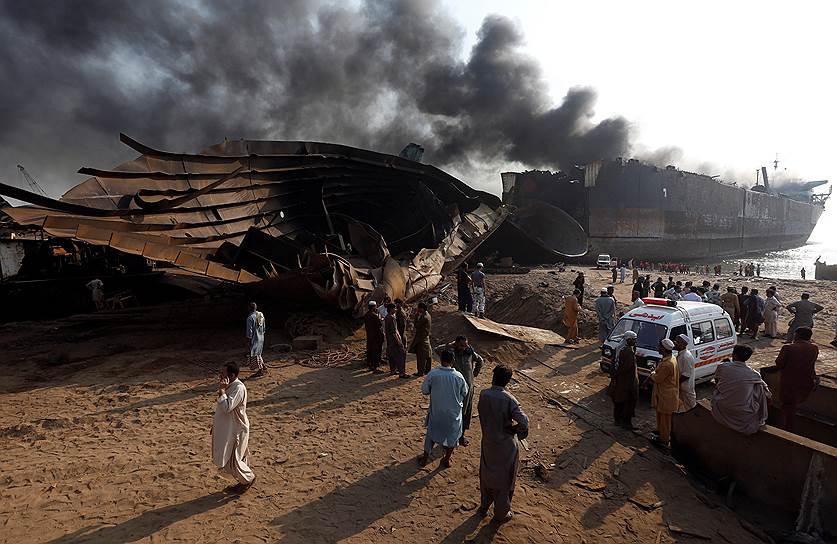 Карачи, Пакистан. Спасатели и члены семей рабочих, пропавших без вести, у горящего нефтяного танкера