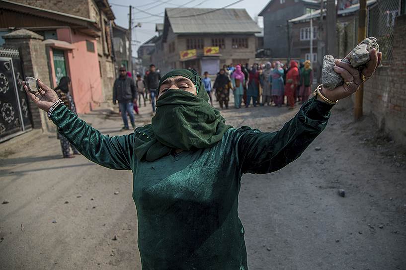 Срингар, Индия. Женщина готовится кинуть камень в полицейских во время рейда 