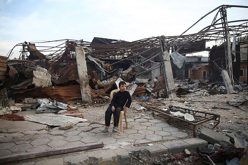 Дамаск, Сирия. Мальчик сидит у разрушенного бомбардировками здания