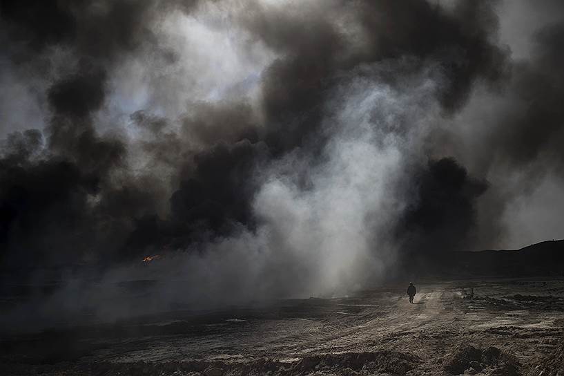 Кайяра, Ирак. Рабочий идет к горящему месторождению нефти, подожженному боевиками «Исламского государства»
