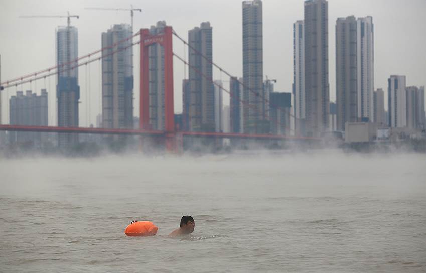 Ухань, Китай. Мужчина плывет по реке Янцзы 