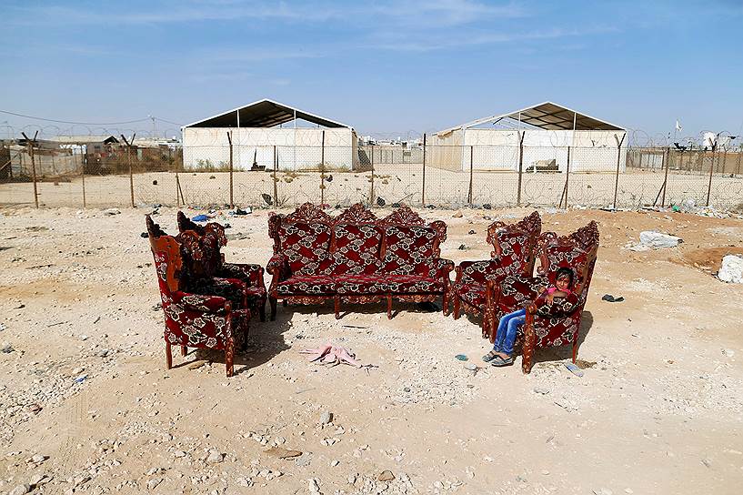 Эль-Мафрак, Иордания. Девочка сидит в кресле, выставленном на продажу в лагере для мигрантов на границе с Сирией