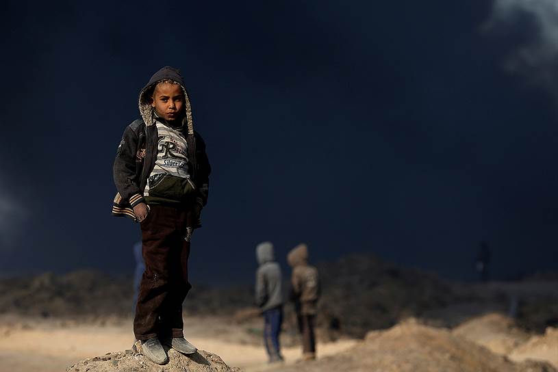Кайяра, Ирак. Мальчик на фоне горящего нефтяного месторождения, подожженного террористами «Исламского государства»