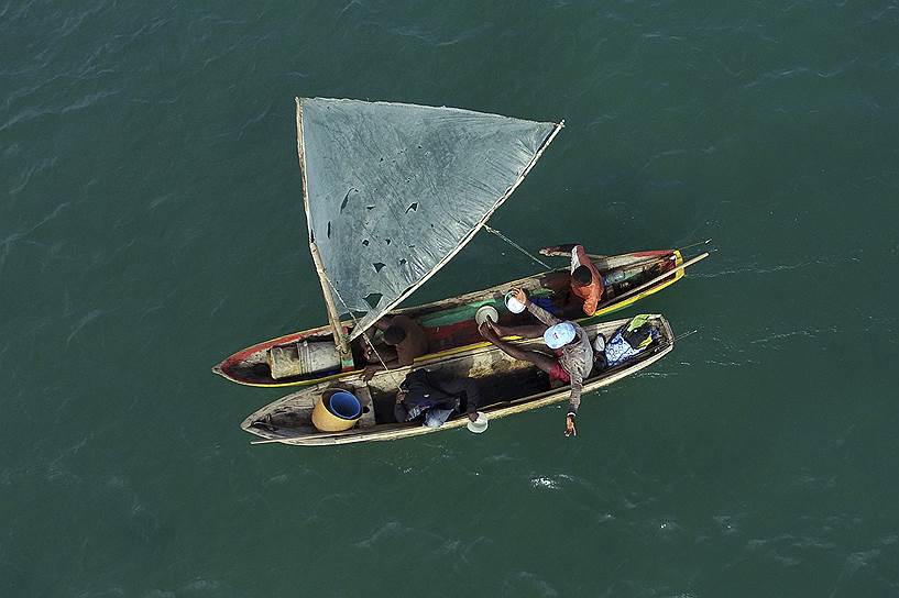 Порт-о-Пренс, Гаити. Местные жители на деревянной лодке во время рыбалки 