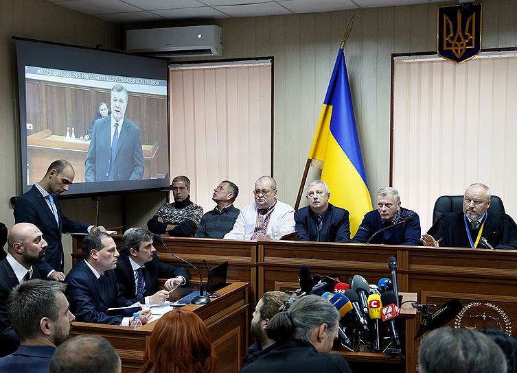 Судья и присяжные заседатели Святошинского районного суда Киева и бывший президент Украины Виктор Янукович (на экране)