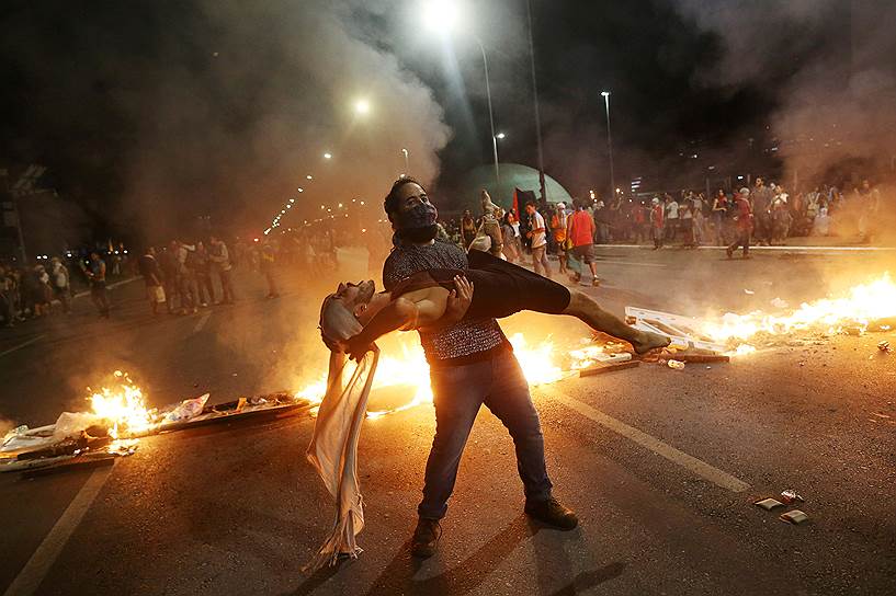 Бразилиа, Бразилия. Демонстранты танцуют на фоне горящих баррикад во время протестов против поправок к конституции страны