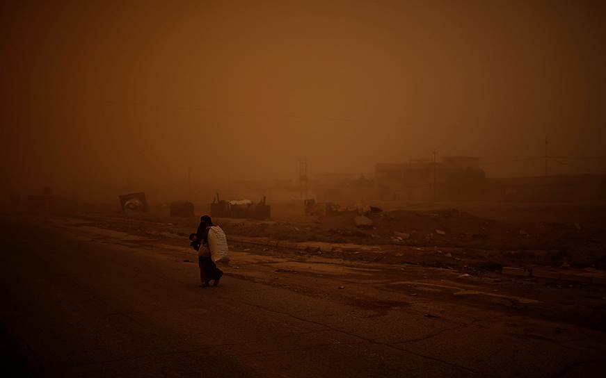 Мосул, Ирак. Женщина с сыном убегает из подконтрольного «Исламскому государству» района Ал-Самах