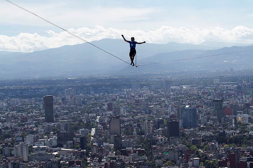 Мехико, Мексика. Немецкий канатоходец Александр Шультц идет по канатам между двумя высотками