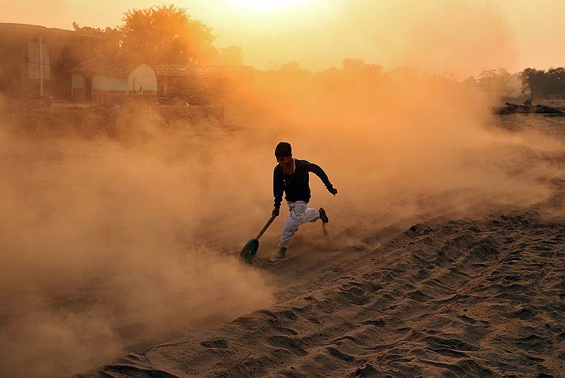 Джамму, Индия. Мальчик играет на пыльной дороге