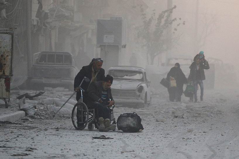 Алеппо, Сирия. Человек на инвалидной коляске вместе с другими местными жителями покидает город