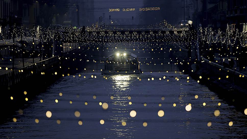 Милан, Италия. Прогулочный катер плывет по украшенному к Рождеству каналу