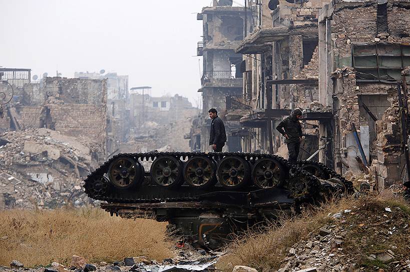 Алеппо, Сирия. Солдаты лояльных президенту страны Башару Асаду объединений стоят на перевернутом танке