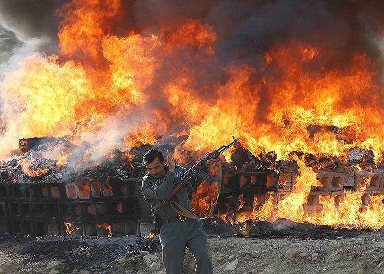 Кабул, Афганистан. Офицер на фоне кучи горящих наркотиков и алкогольных напитков