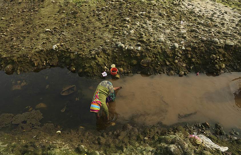 Джамму, Индия. Девочка ловит рыбу голыми руками в высыхающей реке Тави